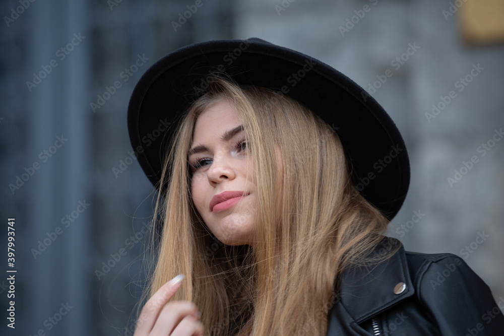 Blonde girl in hat and ferris wheel in modern city, close up Blonde girl in hat and ferris wheel in modern city, close up