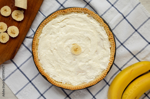 Homemade Tasty Banana Cream Pie on a white wooden background, top view. Flat lay, overhead, from above.