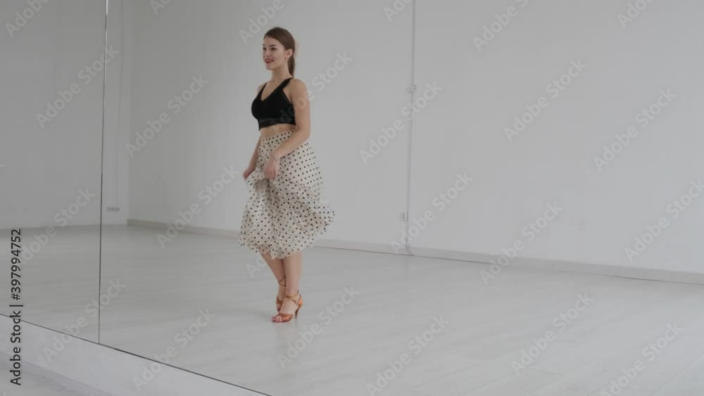 Young beautiful girl dancing ballroom dancing. A professional ballroom dancer is engaged in a large white hall. Young beautiful girl dancing ballroom dancing. A professional ballroom dancer is engaged in a large white hall.