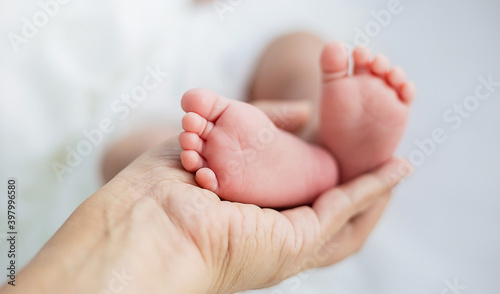 Mother’s hands holding newborn baby feet. Closeup feet of newborn baby. Healthcare and medical love lifestyle father’s day background concept