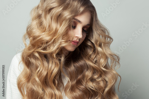Portrait of perfect blonde woman with healthy curly hairstyle on white