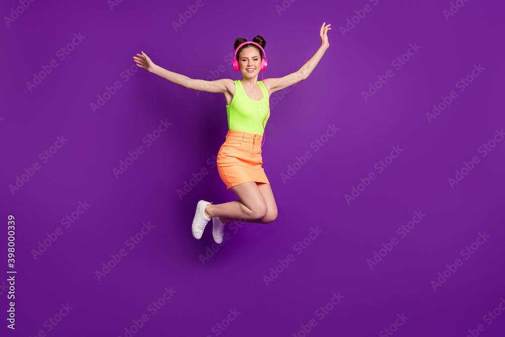 Full length body size view of pretty slender carefree cheerful girl jumping listening single pop isolated on bright violet color background