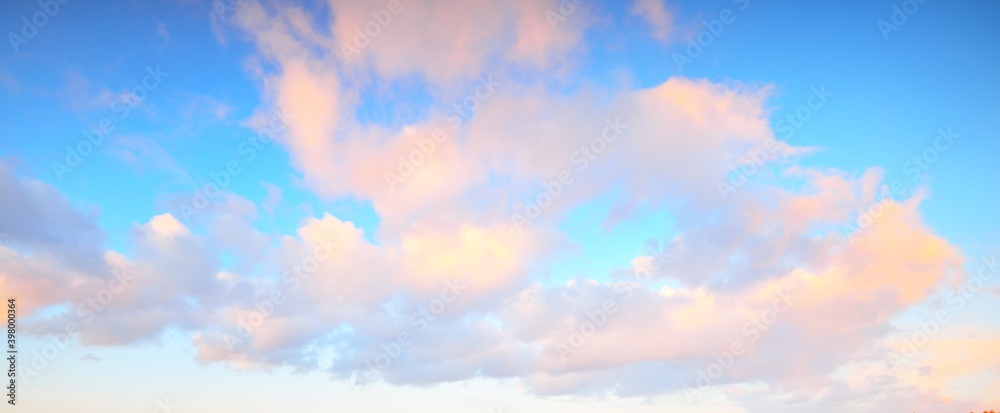Clear blue sky with glowing pink cumulus clouds after a blizzard at sunset. Dramatic winter cloudscape. Concept art, meteorology, heaven, hope, peace, graphic resources, picturesque panoramic scenery - obrazy, fototapety, plakaty 