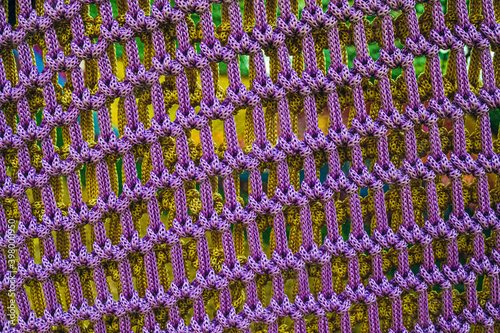 Texture of knitted rope violet fabric. Soft sports and playroom fencing close-up.