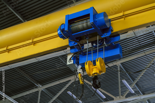 Overhead traveling cathead with steel hooks in industrial engeenering plant shop. Steel slings. photo