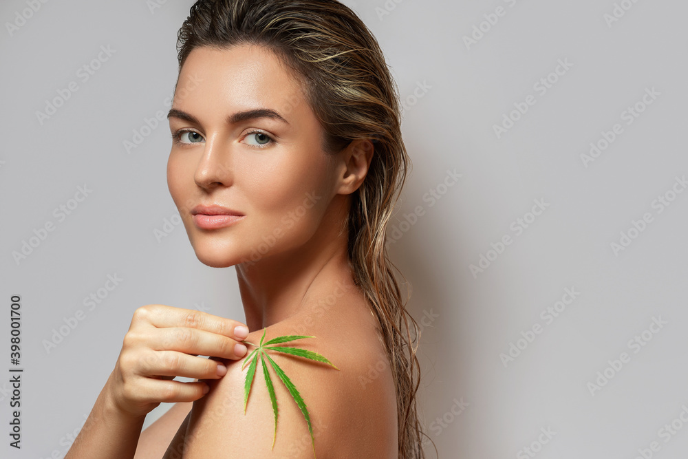 CBD cosmetics concept. Beautiful woman with a cannabis leaf CBD cosmetics concept. Beautiful woman with a cannabis leaf