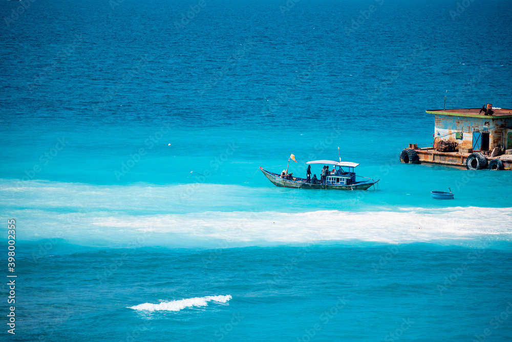Fototapeta premium the boat on the blue sea