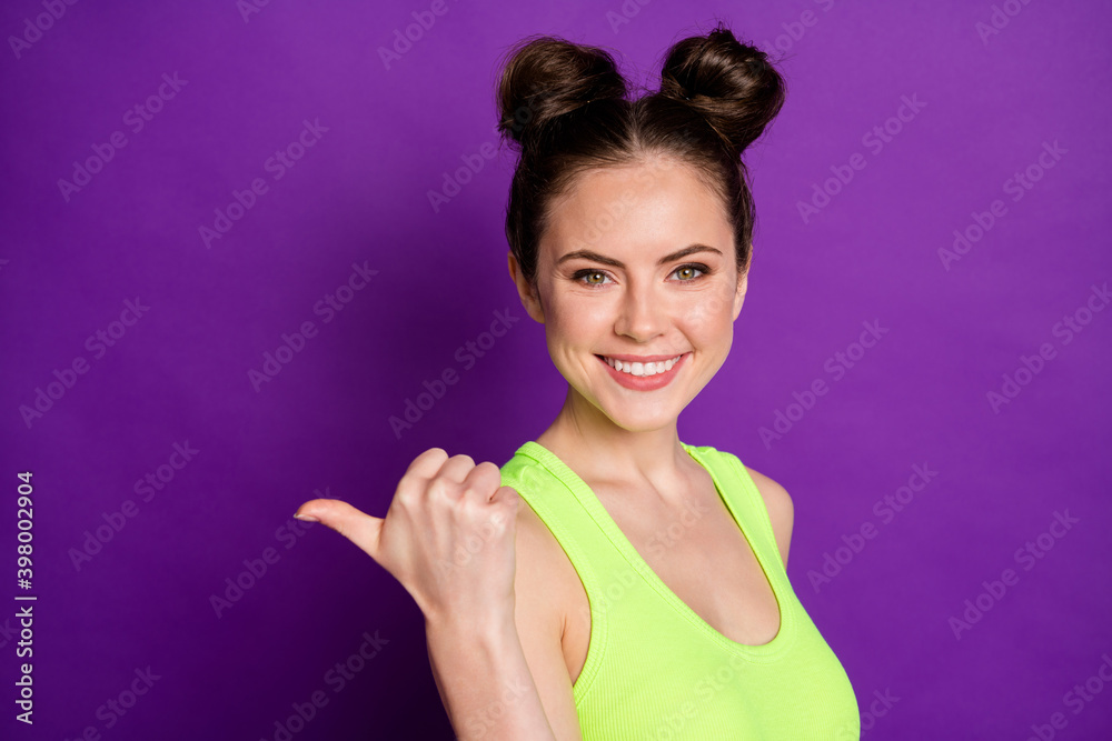 Photo of positive girl promoter point thumb finger copyspace wear tank-top isolated over bright color background Photo of positive girl promoter point thumb finger copyspace wear tank-top isolated over bright color background