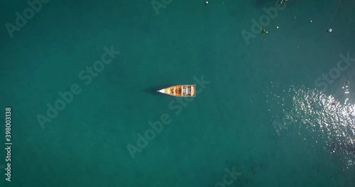 Bird eye view of a small fishing boat floating in a calm Caribbean Sea Marina photo