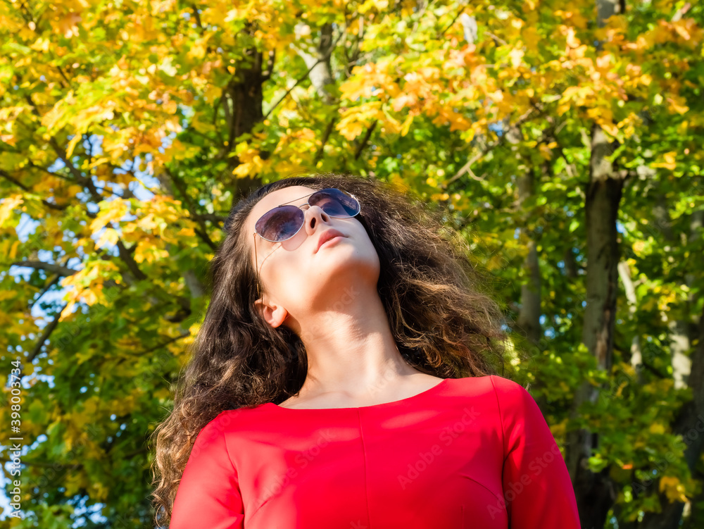 young beautiful girl brunette in sunglasses in Park in autumn