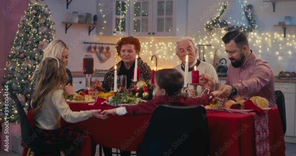 Religious family praying before Christmas dinner Religious family praying before Christmas dinner