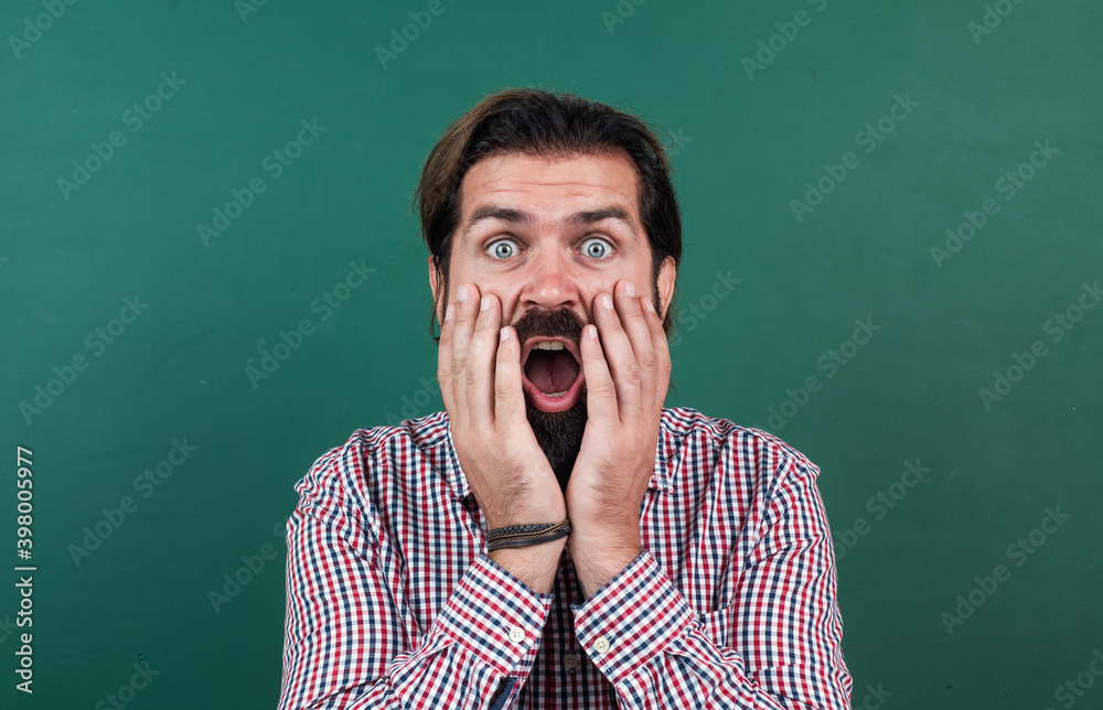 surprised mature bearded man teacher in school classroom with blackboard, back to school surprised mature bearded man teacher in school classroom with blackboard, back to school
