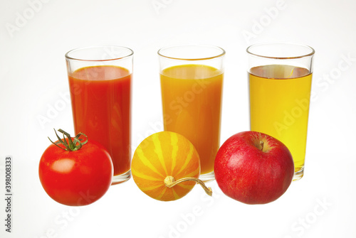 Three glasses with tomato  pumpkin  orange juice and tomato  pumpkin  orange on a white background.