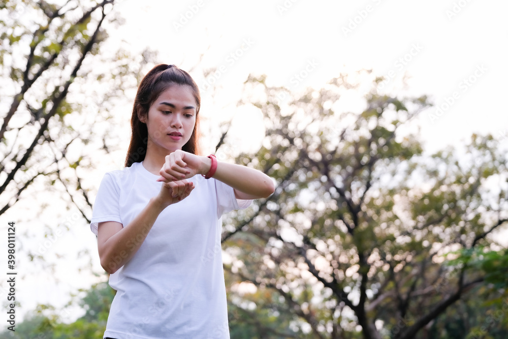 Attractive young fitness woman checking smartwatch tracker. Young woman looking on smartwatch her heartbeat. Attractive young fitness woman checking smartwatch tracker. Young woman looking on smartwatch her heartbeat.