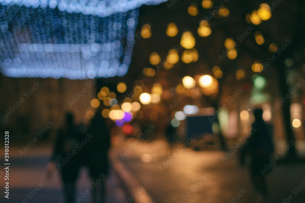 Obraz premium Blurred image of night european city in christmas illumination, urban background and texture