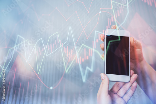 Double exposure of forex graph sketch hologram and woman holding and using a mobile device. Stock market concept.