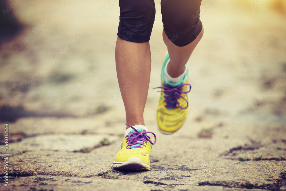 Young fitness woman hiker legs walking  on trail