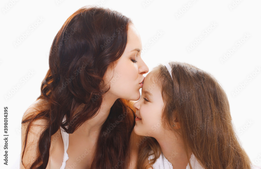 Portrait close up of happy mother kissing her daughter child over a white background Portrait close up of happy mother kissing her daughter child over a white background