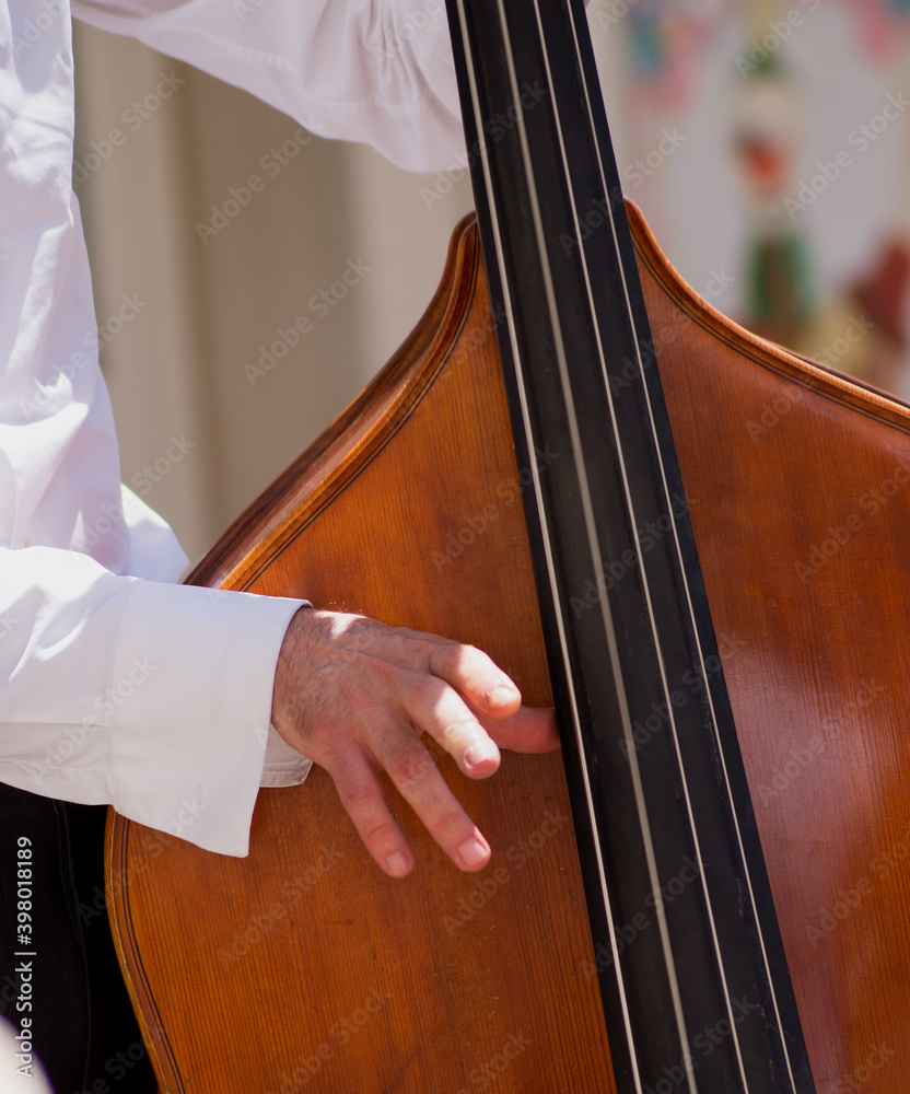 Meran, South Tirol, Italy - Circa June 2017: closeup of an upright bass being played during the yearly street festival asfaltart in Meran