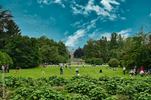 Fototapeta Naklejka Na Ścianę i Meble -  Arch of Peace, Arco della Pace gate and green trees, flowers, grass lawn in Parco Sempione park with blue cirrus cloudy sky