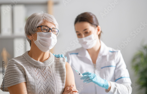 Doctor giving a senior woman a vaccination