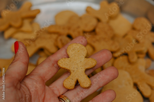 Female hand holding christmas cookie. Blurred background.