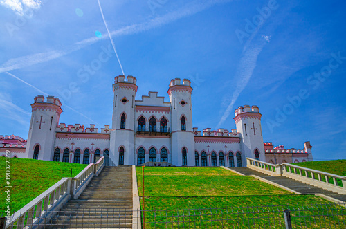 Puslowski palace castle building in Kosava Kossovo with staircase and green lawn in sunny summer day, blue sky background, Brest region, Belarus photo