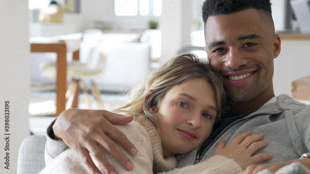 Mixed-raced couple relaxing in sofa, embracing each other Mixed-raced couple relaxing in sofa, embracing each other