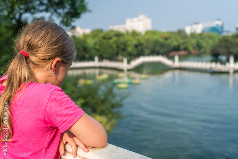 Girl admiring Shan Lake in Riyue Shuangta Cultural Park in guilin Girl admiring Shan Lake in Riyue Shuangta Cultural Park in guilin