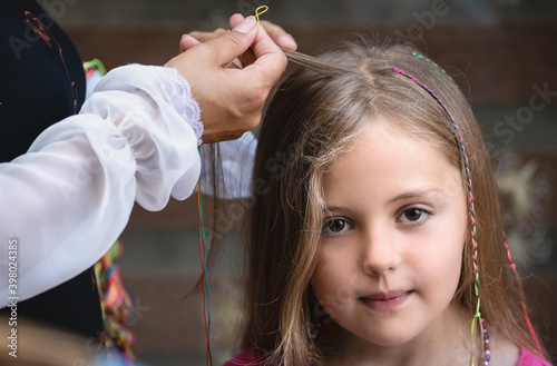 Chinese woman braiding Caucasiuan girl hair photo