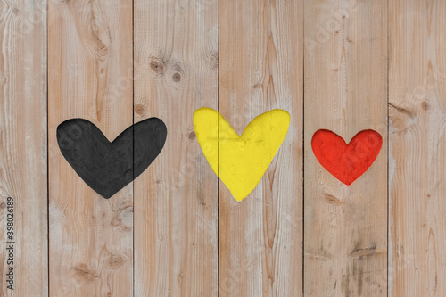 Belgian flag colors carved into wooden love hearts
