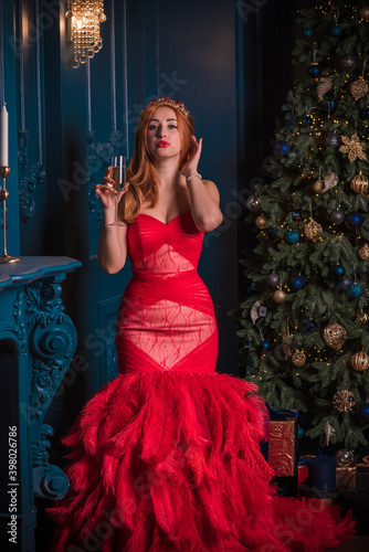 Christmas party, modern woman celebrate, lifestyle. Girl in luxury red dress with feathers, inspirations and New Year