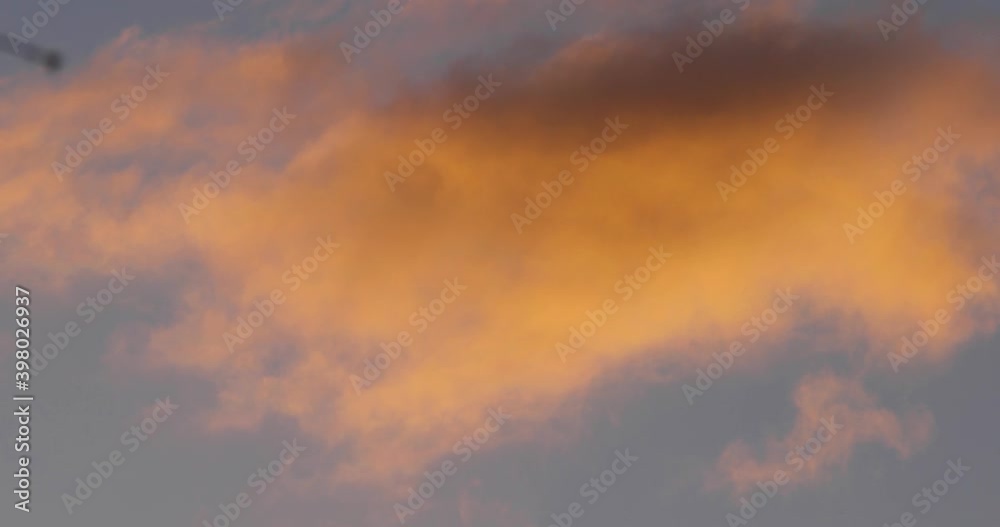 Puffy pink and white clouds passing at fast-forward speed blue sky in the background Puffy pink and white clouds passing at fast-forward speed blue sky in the background
