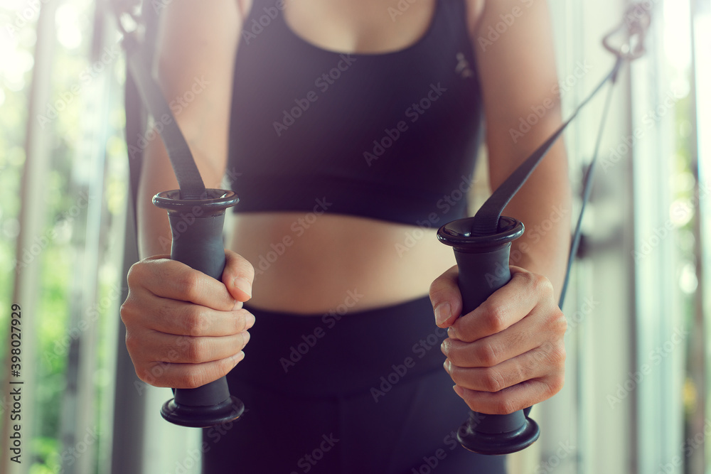 Young woman with perfect body training triceps with cable exercise machine in the gym. Concept fitness ,workout, gym exercise ,lifestyle and healthy.