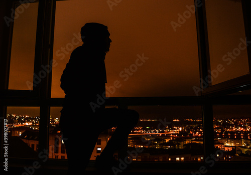 man at the window of his house in confinement