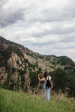 Scenic view of the large mountains on a cloudy summer day. Young woman is hiking at the park  with red mountains. Settlers park, Boulder, Colorado, USA. Denver