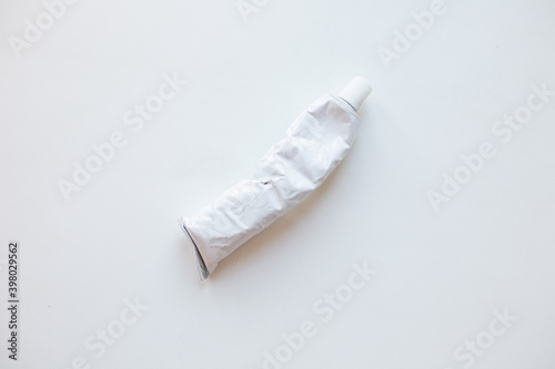white rumpled tube of paint on a white background