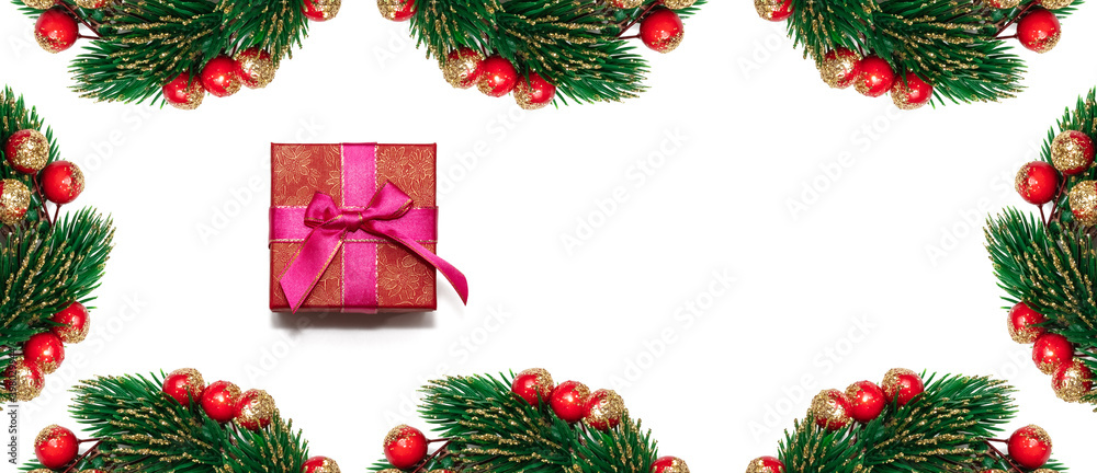 Decorative Christmas spruce branches with red, golden berries encircling white copy space and red gift box. Isolated on white background. Winter holiday postcard, decoration concept. Banner size Decorative Christmas spruce branches with red, golden berries encircling white copy space and red gift box. Isolated on white background. Winter holiday postcard, decoration concept. Banner size
