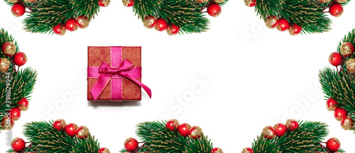 Decorative Christmas spruce branches with red, golden berries encircling white copy space and red gift box. Isolated on white background. Winter holiday postcard, decoration concept. Banner size
