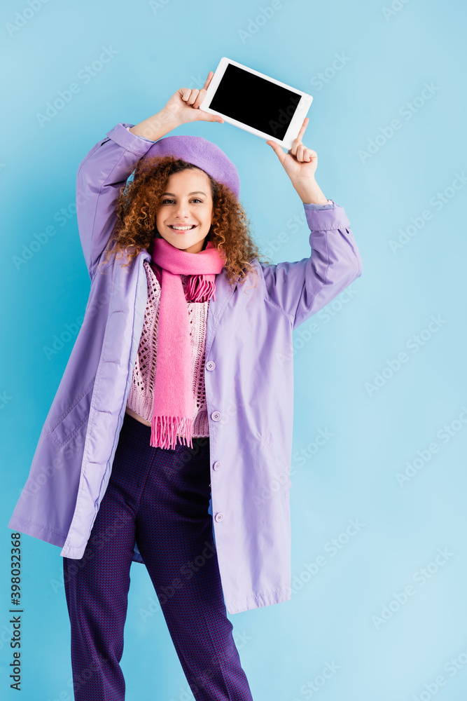 Φωτογραφία happy young woman in winter coat, beret and pink knitted scarf holding digital t