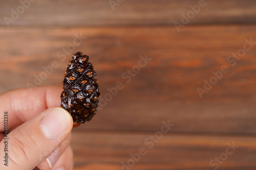 Sweet pine cone candy in black plate on wooden background. Healthy dessert, nutrition, jam recipe concept. Close-up, copy space