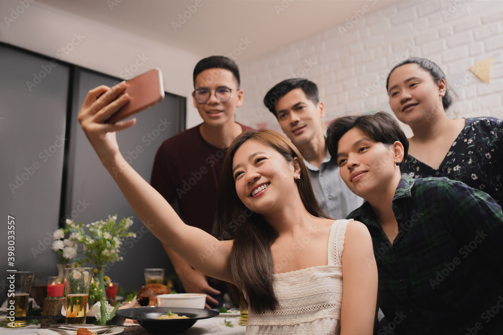 Obraz premium Group of Asian friends taking pictures at a party. They are happy.
