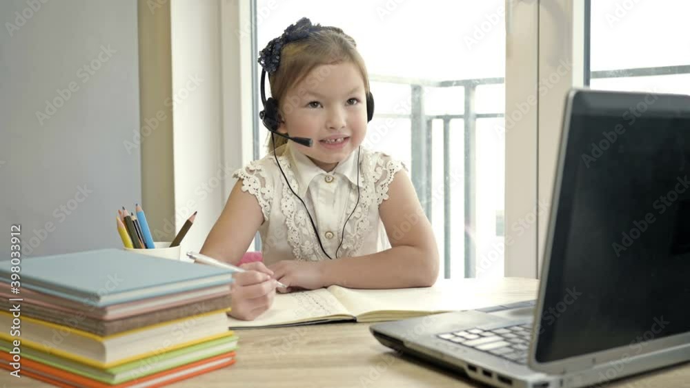 Little girl communicates with a teacher via the Internet. Online training during quarantine. Little girl communicates with a teacher via the Internet. Online training during quarantine.