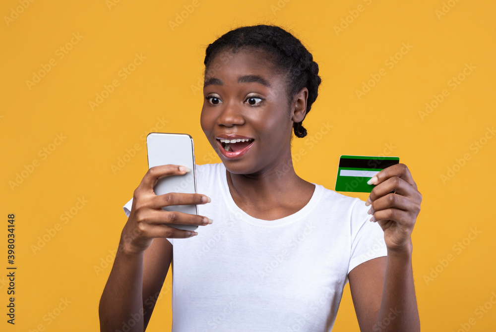 Black Woman Holding Credit Card And Smartphone Shopping, Yellow Background