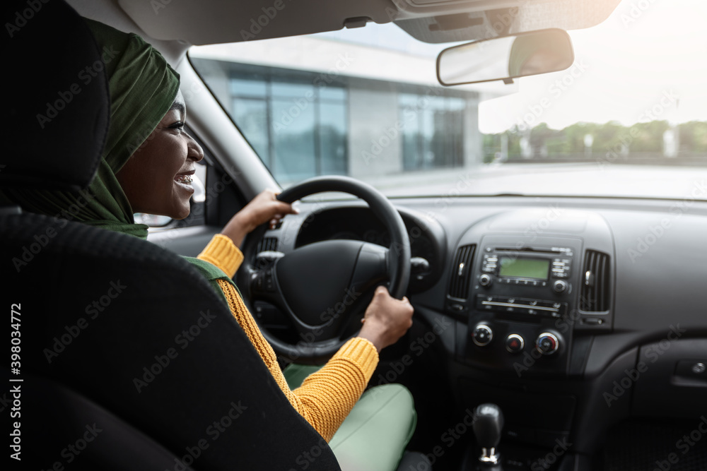 Vehicle Insurance. Happy Black Muslim Lady Sitting On Driver's Seat In Car