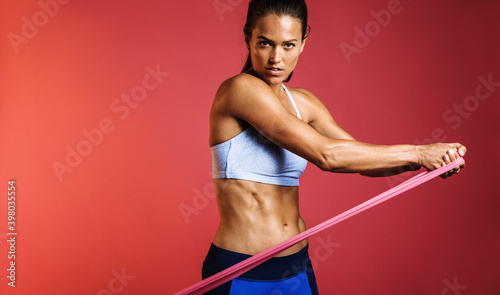 Muscular woman using resistance bands for training