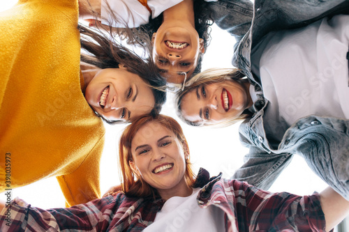 Group of happy female friends huddling outdoors