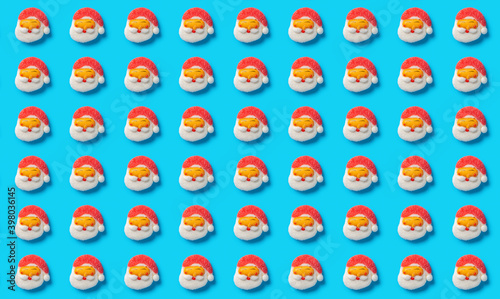 pattern of cute Santa Claus candies on a blue background