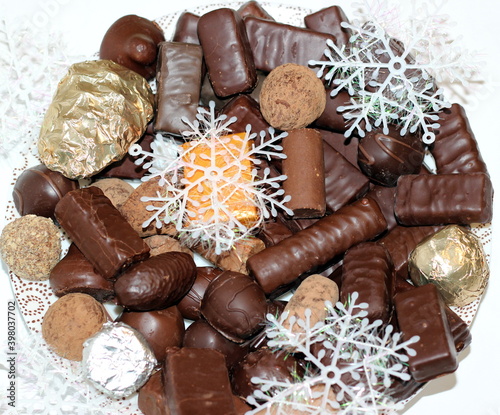 chocolate and Christmas decorations on white background