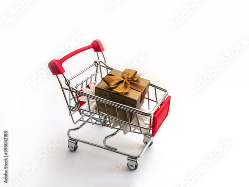 Close-Up Of Shopping Cart With Box Over White Background
